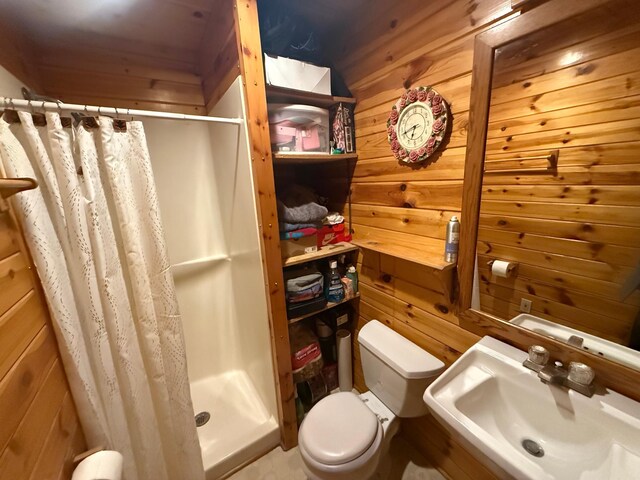 full bath featuring wood walls, a stall shower, toilet, and a sink