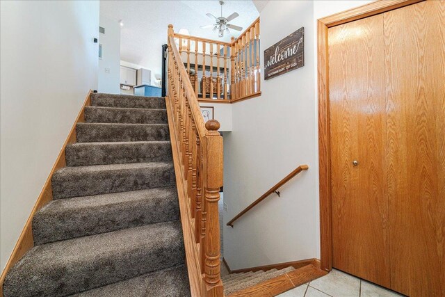 stairway with tile patterned floors, baseboards, and a ceiling fan