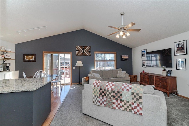 living room with lofted ceiling, light wood-style floors, baseboards, and ceiling fan