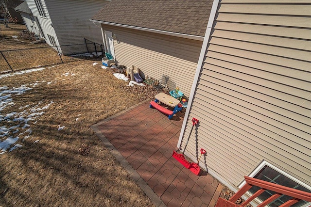 view of home's exterior featuring roof with shingles and fence