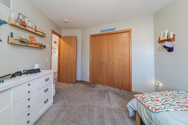 carpeted bedroom with a closet, baseboards, a textured ceiling, and visible vents