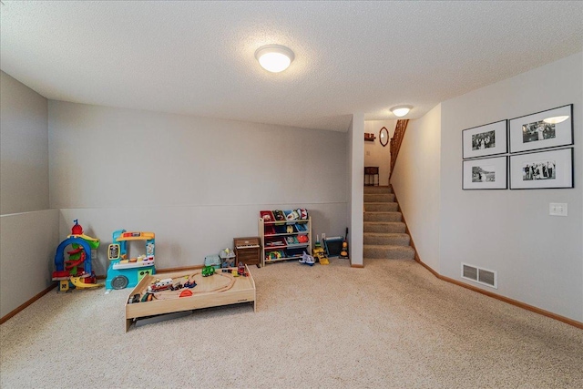 rec room with carpet flooring, baseboards, visible vents, and a textured ceiling