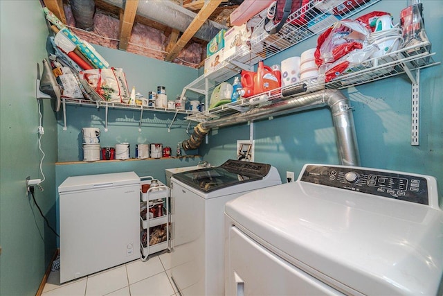 clothes washing area with washer and dryer, laundry area, and tile patterned floors