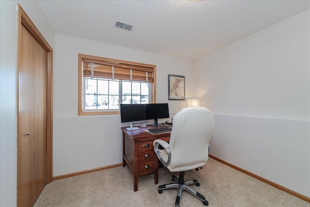 office featuring a textured ceiling, light colored carpet, visible vents, and baseboards