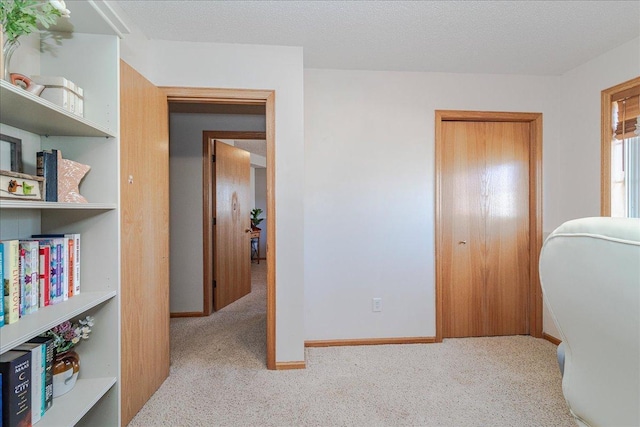 carpeted home office featuring baseboards and a textured ceiling