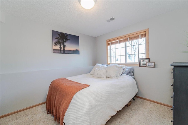 carpeted bedroom featuring visible vents, a textured ceiling, and baseboards