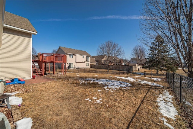 yard layered in snow with stairs, a fenced backyard, a residential view, and a wooden deck