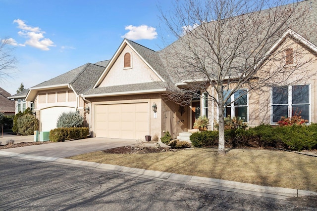 view of front facade featuring a shingled roof, an attached garage, driveway, and stucco siding