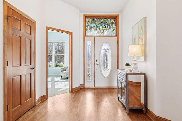 foyer entrance with light wood-type flooring and baseboards