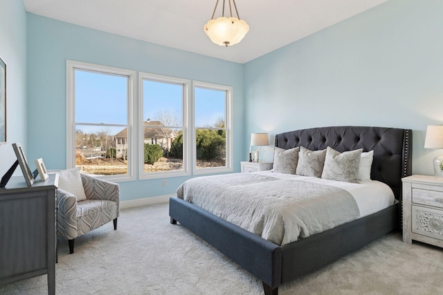 bedroom featuring light colored carpet and baseboards