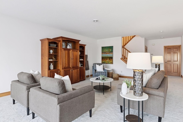 living area with light colored carpet, stairs, and baseboards