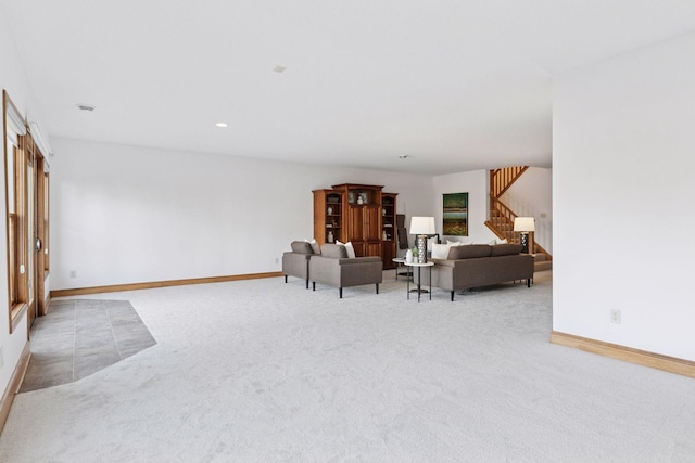 living room featuring recessed lighting, stairway, baseboards, and light colored carpet