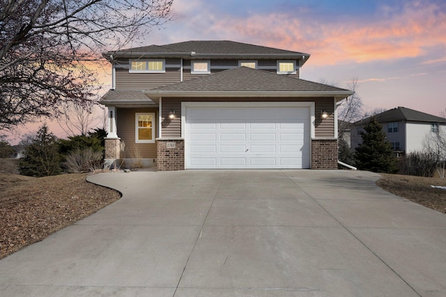 view of front of house with brick siding, an attached garage, concrete driveway, and a shingled roof