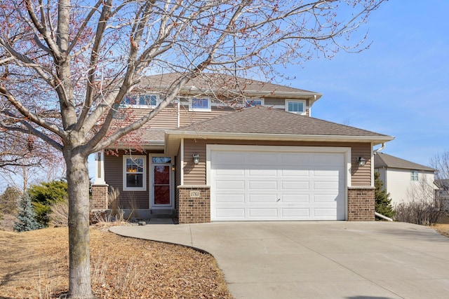 view of front of house featuring brick siding, an attached garage, driveway, and roof with shingles