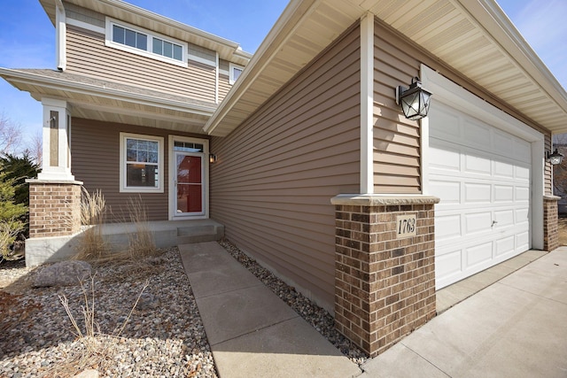 entrance to property with concrete driveway, central air condition unit, and a garage