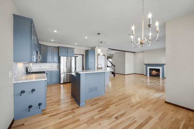 kitchen with light wood-type flooring, visible vents, appliances with stainless steel finishes, light countertops, and decorative backsplash