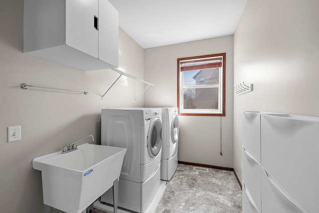 washroom with a sink, baseboards, independent washer and dryer, and laundry area