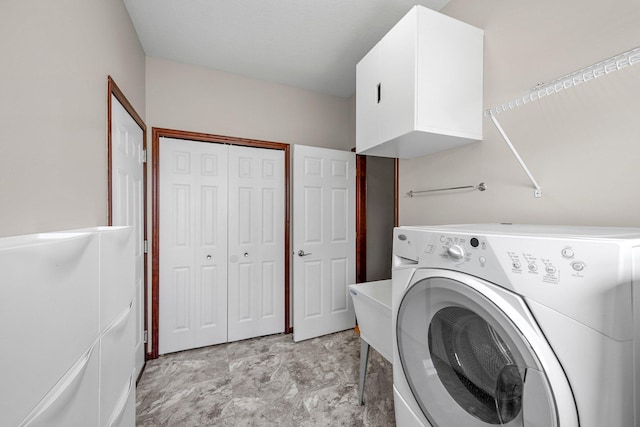 washroom featuring cabinet space and washer / clothes dryer