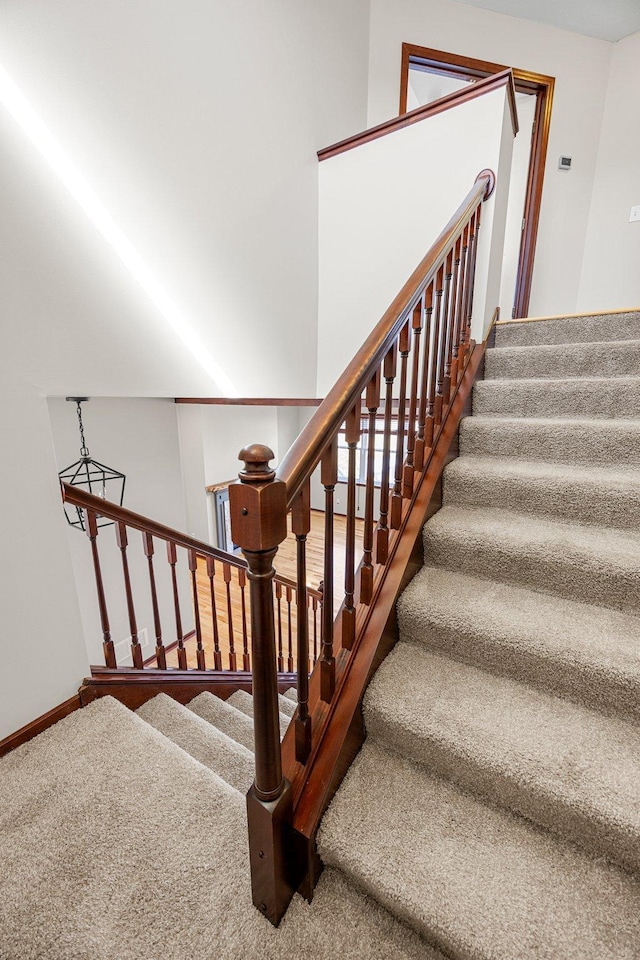 staircase with baseboards and carpet floors