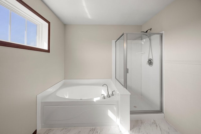 bathroom featuring a garden tub, marble finish floor, and a stall shower