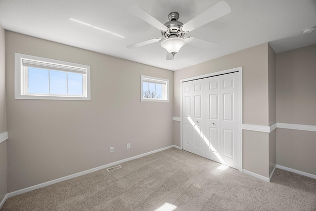 unfurnished bedroom with a closet, baseboards, visible vents, and carpet floors