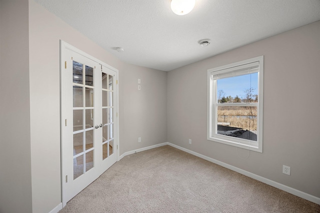 empty room featuring a textured ceiling, baseboards, and carpet floors