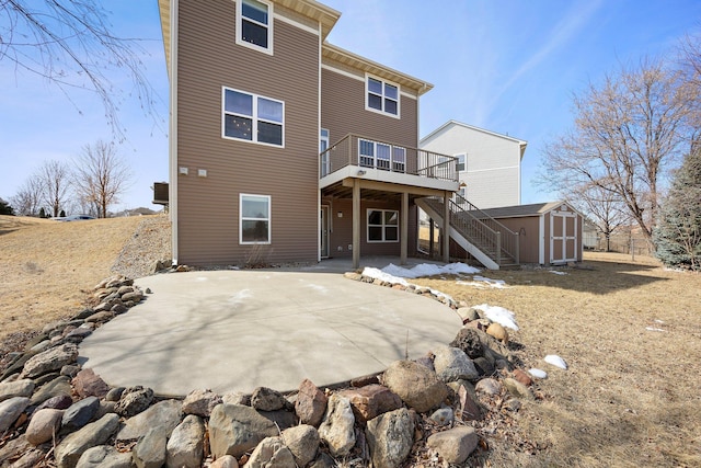 back of house with stairs, a storage shed, a deck, a patio area, and an outbuilding