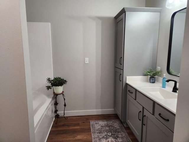 full bathroom featuring vanity, baseboards, and wood finished floors