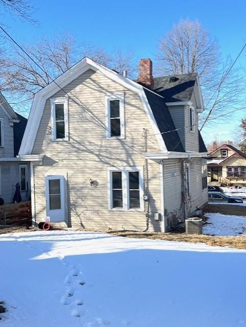 exterior space with a gambrel roof and a chimney