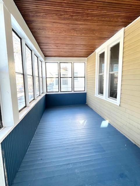 unfurnished sunroom featuring plenty of natural light and wood ceiling