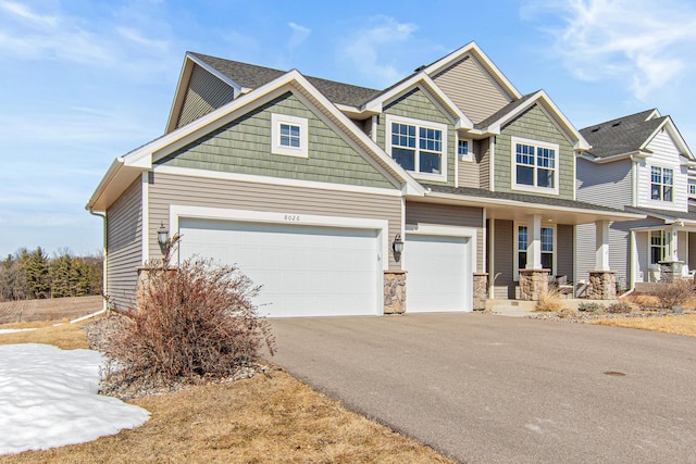 craftsman-style house featuring a porch, an attached garage, stone siding, and driveway