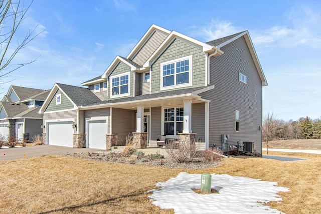 craftsman-style home with central air condition unit, driveway, stone siding, a porch, and a shingled roof