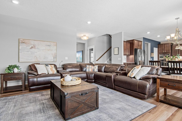 living area with a chandelier, stairway, recessed lighting, wood finished floors, and a textured ceiling