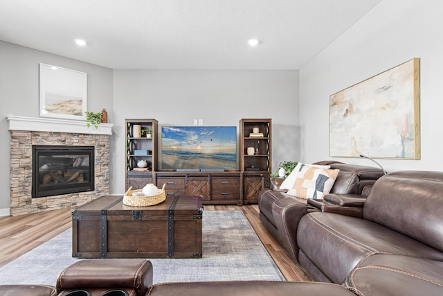 living room featuring a fireplace, recessed lighting, and wood finished floors