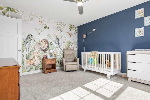 carpeted bedroom with a ceiling fan, visible vents, baseboards, wallpapered walls, and an accent wall