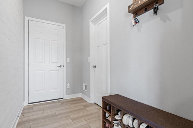 mudroom featuring baseboards, visible vents, and wood finish floors