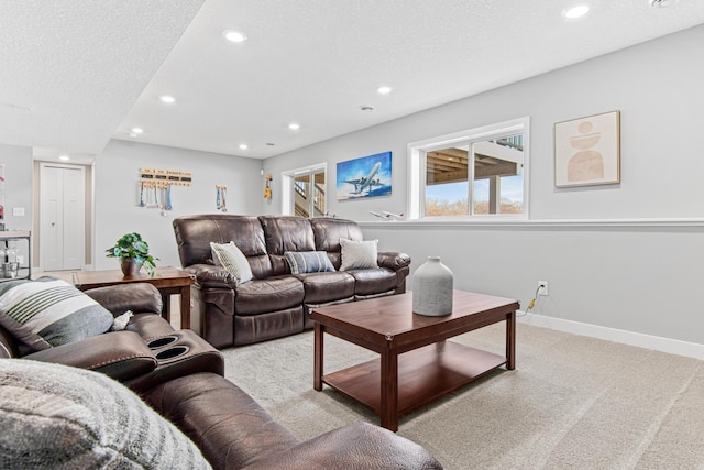 living area featuring recessed lighting, light colored carpet, baseboards, and a textured ceiling