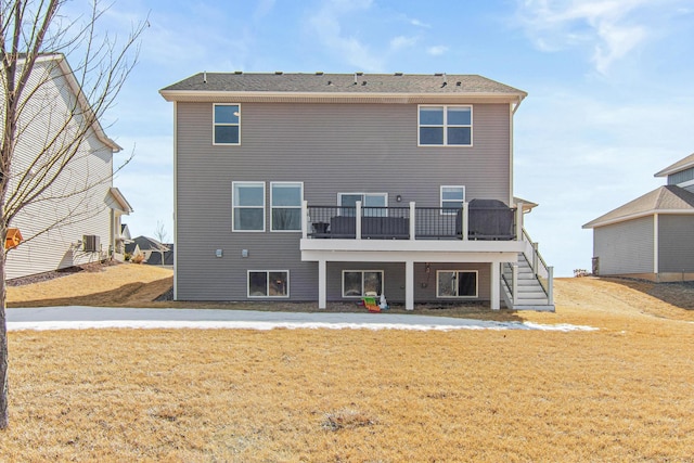 back of house featuring a lawn, a wooden deck, and stairs