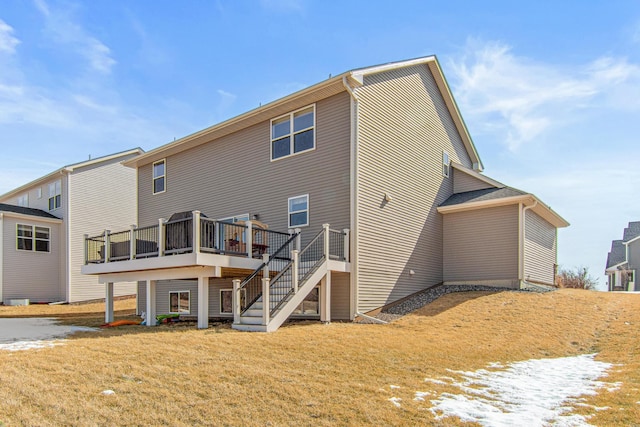 back of property featuring a wooden deck, a yard, and stairway