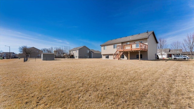 back of house with a deck and a lawn