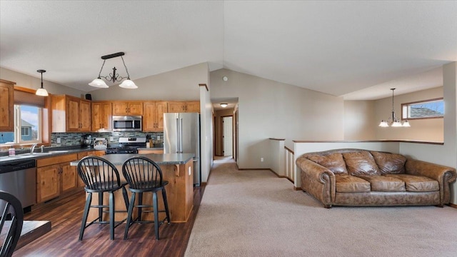 kitchen with stainless steel appliances, a kitchen bar, dark countertops, tasteful backsplash, and open floor plan