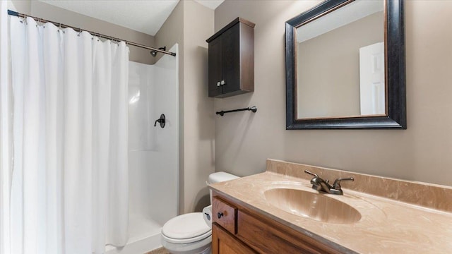 bathroom featuring vanity, a shower stall, toilet, and a textured ceiling