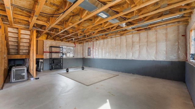 below grade area featuring a wood stove and concrete block wall