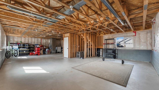 basement featuring concrete block wall and visible vents