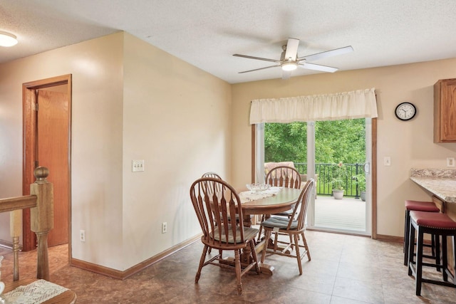 dining space featuring a textured ceiling, baseboards, and ceiling fan