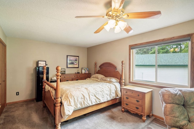 bedroom with light colored carpet, a textured ceiling, baseboards, and a ceiling fan