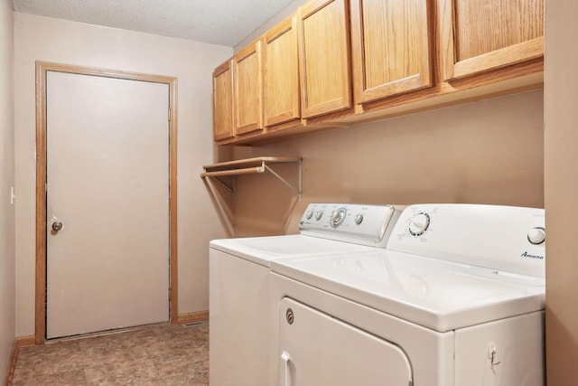 washroom with cabinet space, a textured ceiling, and washing machine and dryer