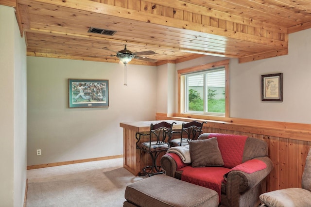 living area with visible vents, wooden ceiling, baseboards, and carpet