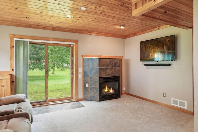 unfurnished living room with visible vents, carpet floors, baseboards, a fireplace, and wooden ceiling