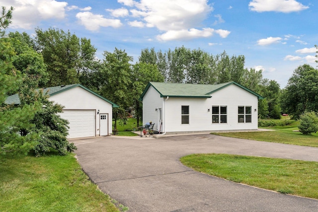 view of front of house with a garage, an outdoor structure, and a front lawn